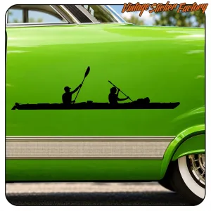 Silhouette of a double kayak with two people paddling on the door of a green vehicle