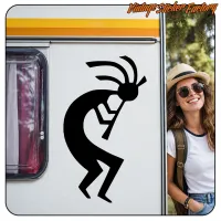 Silhouette noire de Kokopelli sur une caravane, à côté d’une personne portant un chapeau