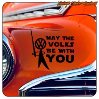 Détail du design « MAY THE VOLKS BE WITH YOU » posé sur la carrosserie d’un véhicule orange