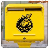 Adhesivo con figura vikinga y texto VOLVO aplicado en un buzón amarillo