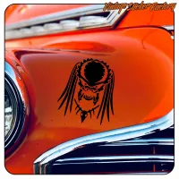 Pegatina negra de criatura extraterrestre sobre la carrocería naranja de un automóvil clásico
