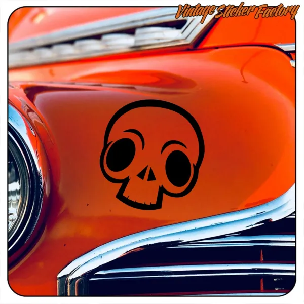 Detail eines schwarzen Totenkopfs auf orangefarbener Karosserie mit Chromleisten