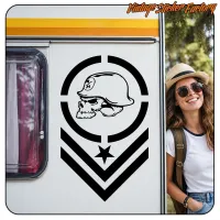 Skull design with helmet, star and chevrons applied to a caravan, beside a person