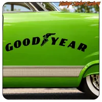 GOOD YEAR en negro sobre la carrocería verde de un coche clásico, junto a la rueda trasera