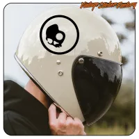 Close-up of the circular sticker with a black skull placed on a motorbike helmet