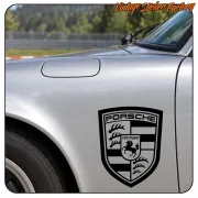 Schwarz-weißes Porsche-Emblem an der Seite eines silbernen Autos angebracht