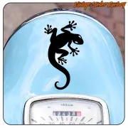 Gecko negro aplicado sobre la parte frontal azul de una motocicleta