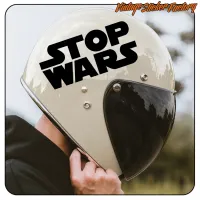 Détail de l’autocollant STOP WARS noir sur un casque à visière sombre