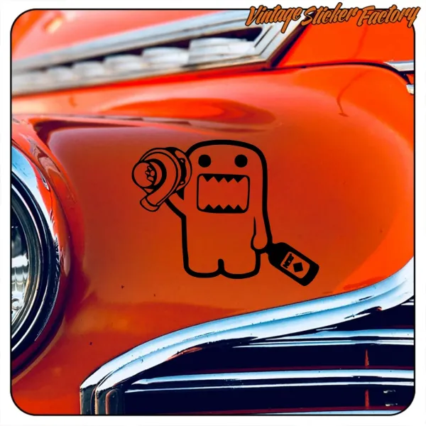 Diseño negro de Domo-Kun con turbocompresor aplicado sobre la carrocería de un coche naranja