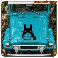 Frontansicht eines türkisfarbenen Fahrzeugs mit Totoro-Motiv auf der Motorhaube