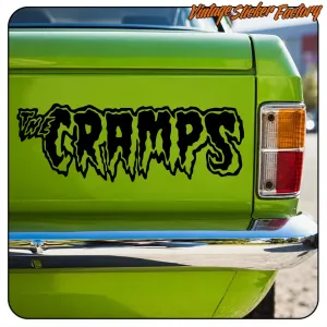 Black “THE CRAMPS” adhesive applied to the rear of a green vehicle