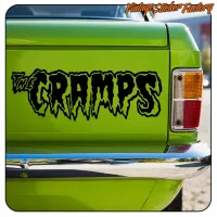 Vue de l’adhésif noir « THE CRAMPS » appliqué près du feu arrière d’un véhicule vert