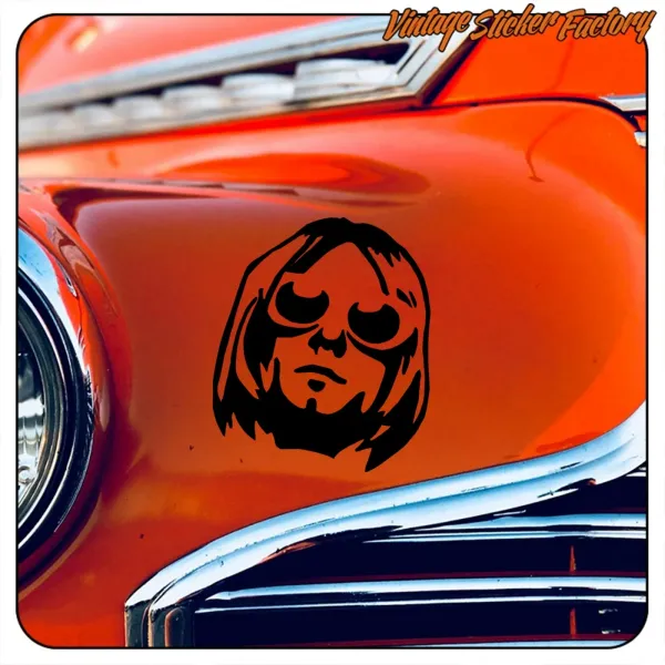 Portrait stylisé noir de Kurt Cobain appliqué sur la carrosserie orange d’une voiture