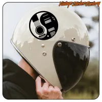 Détail du motif yin-yang avec guitare posé sur un casque de moto