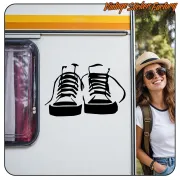 Dos zapatillas negras en el lateral de una caravana junto a una mujer