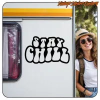 Design typographique STAY CHILL noir appliqué sur le côté d’une caravane