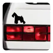 Schwarze Silhouette eines Schnauzers neben den Rückleuchten eines Fahrzeugs