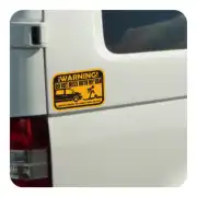 Mehrfarbiger Warnaufkleber auf der hinteren Tür eines weißen Transporters