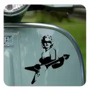 Vinilo pin-up con guitarra aplicado sobre una pieza azul clara de vehículo.