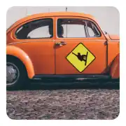 Snowboard-Aufkleber mit gelber Raute und schwarzer Silhouette an der Tür eines klassischen orangefarbenen Autos