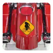 Autocollant jaune avec un cycliste à vélo appliqué à l’arrière d’une moto rouge