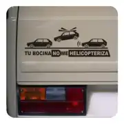 Vinilo con coches, helicóptero y texto aplicado junto al piloto trasero de un vehículo.