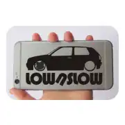 «LOW/SLOW» sticker with a Volkswagen Golf silhouette held in front of a mobile phone.