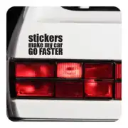 Adhésif avec la phrase « STICKERS MAKE MY CAR GO FASTER » appliqué près du feu arrière d’une voiture blanche