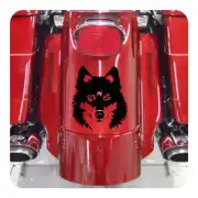 Pegatina de lobo negro colocada en una moto roja.