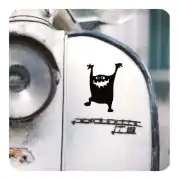 Monstre noir appliqué sur le côté blanc d’un véhicule ancien