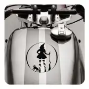 Pegatina de bruja y gatos aplicada sobre el depósito de una moto