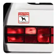 CAUTION AREA PATROLLED sticker placed on the rear of a white vehicle