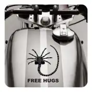 Adhésif avec une créature arachnéenne et le texte «FREE HUGS» appliqué sur le réservoir d’une moto