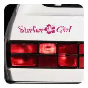 Pegatina «Surfer Girl» rosa aplicada sobre la parte trasera blanca de un vehículo