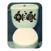 Sticker of two black fish applied to the top of a toilet