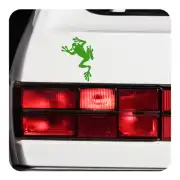 Green frog silhouette sticker applied next to the rear lights of a white vehicle