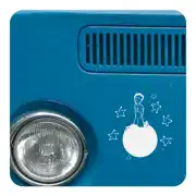 Adhesivo del Principito sobre un vehículo azul, junto a un faro y una rejilla