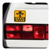 “DEVIL IN CAR” sticker placed on the tailgate of a white vehicle