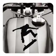 Silueta negra de una persona saltando sobre un monopatín, aplicada en el depósito de una moto