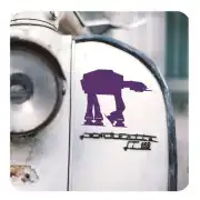 Silueta morada de un AT-AT aplicada en una superficie metálica junto a una moto