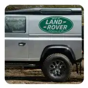 Ovaler Aufkleber «Built by Land Rover Improved by Me» an der Seite eines grauen Transporters