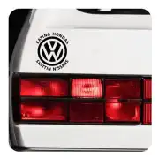 Circular sticker with VW emblem and text on the rear of a white vehicle