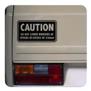 Vinilo CAUTION aplicado junto al piloto trasero de un vehículo