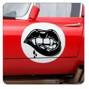 Schwarze Lippen mit Reißzähnen an der roten Tür eines klassischen Autos