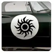 Schwarzes Tribal-Sonnenmotiv an der Tür eines dunklen Fahrzeugs