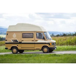 Camper beige vista de perfil con emblema y franjas laterales