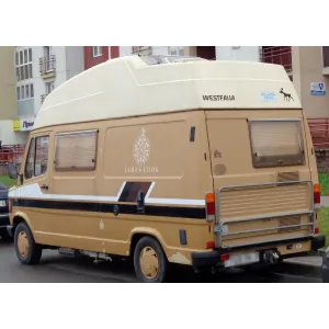 Parte trasera de una camper beige con emblema lateral y gráficos decorativos